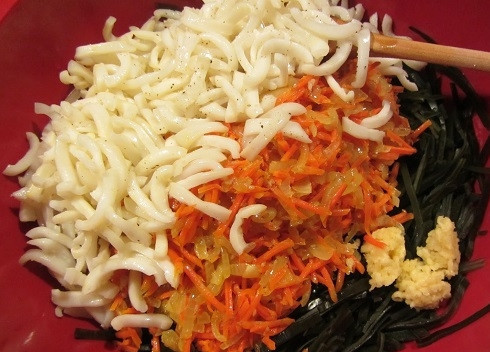 1. Этап. Салат из морской капусты и кальмаров: Выкладываем в миску капусту, морковь с луком, кальмаров и измельченный чеснок.