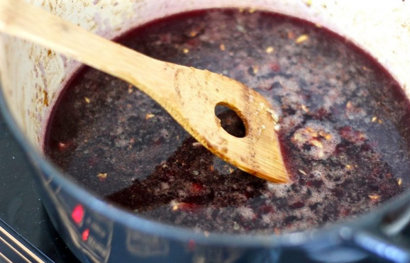 1. Этап. Говядина в вине в духовке: 7. Спустя несколько минут влейте красное вино, лопаткой соскребите все со дна кастрюли. Кипятите содержимое на слабом огне до его уменьшения в 2 раза.