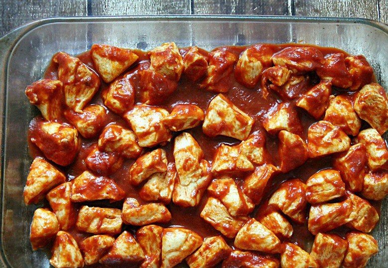 1. Этап. Тефтели с картошкой в духовке: 1. Вымыть и очистить картофель, нарезать средними кусочками. На сковороде разогреть растительное масло. Отправить туда картофель и обжарить на сильном огне до появления корочки. Затем снять со сковороды и выложить в жаропрочную формы. Сверху вылить томатный соус (можно использовать острый или пряный).