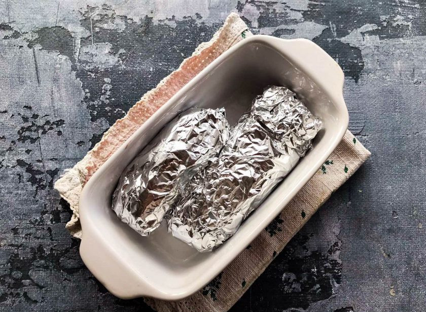 1. Этап. Куриные рулетики с творогом и зеленью в духовке: Заверните рулетики в фольгу, выложите в жаропрочную форму и отправьте в предварительно разогретую духовку до 180 градусов на 25 минут.