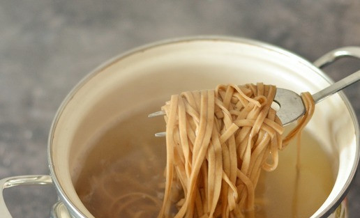 1. Этап. Гречневая лапша в пикантном томатном соусе: Готовить блюдо нужно параллельно на двух конфорках. На одной варим лапшу, на другой - готовим сразу же соус. Вскипятите в кастрюле достаточное количество воды с добавлением соли и отварите лапшу на 2 минуты меньше, чем рекомендовано производителем на упаковке, поскольку потом мы будем доводить до готовности лапшу в соусе. Мне производитель рекомендует варить лапшу всего 3 минуты. Поэтому я опустила её в кипяток всего на 1 минуту. Лапшу откиньте на сито и немного воды от варки сохраните.