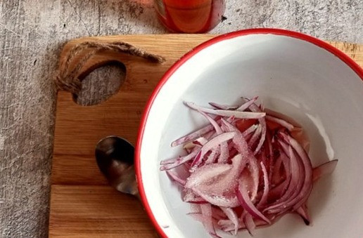 1. Этап. Огуречный салат с сыровяленой индейкой: Нужно сразу замариновать лук красный. Режем луковицу перьями тонкими. Помещаем в посуду, заливаем винным уксусом из красного вина, добавляем сахар. Перемешиваем и занимаемся салатом.