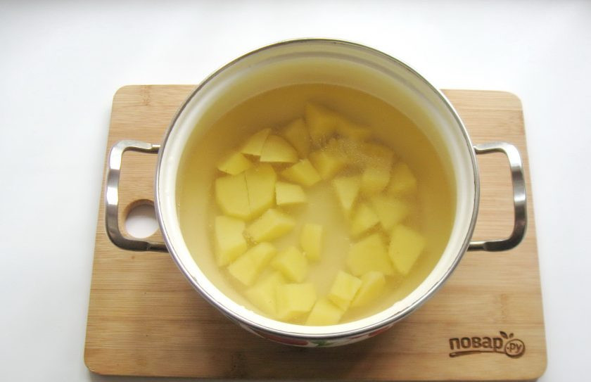 1. Этап. Борщ с пекинской капустой: Картофель очистите, помойте и нарежьте кубиками, выложите в кастрюлю. Залейте картофель любым мясным бульоном. У меня куриный. Поставьте кастрюлю на плиту.