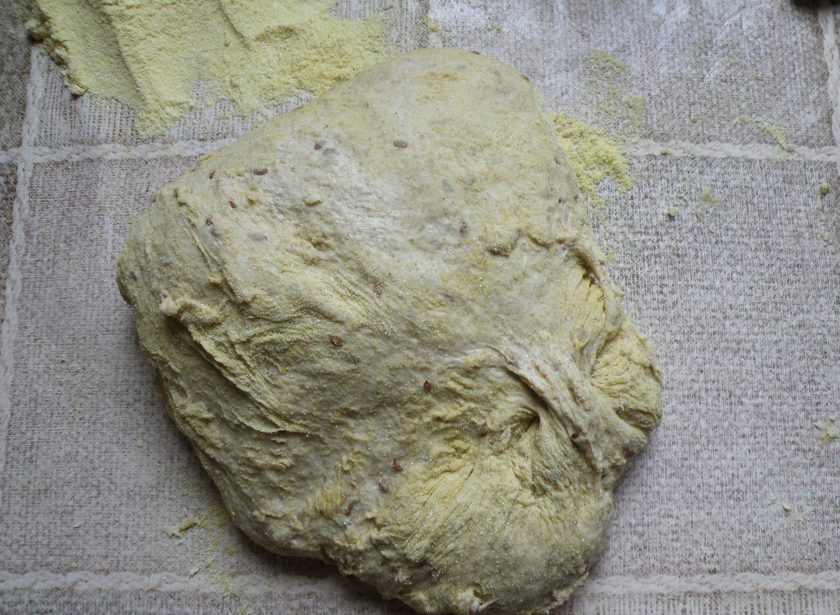 1. Этап. Отрубной хлеб на горчичном масле: Готовое тесто выложите на стол, подсыпав пару ложек кукурузной муки. Обкатайте в ней тесто, формируя круглый каравай.