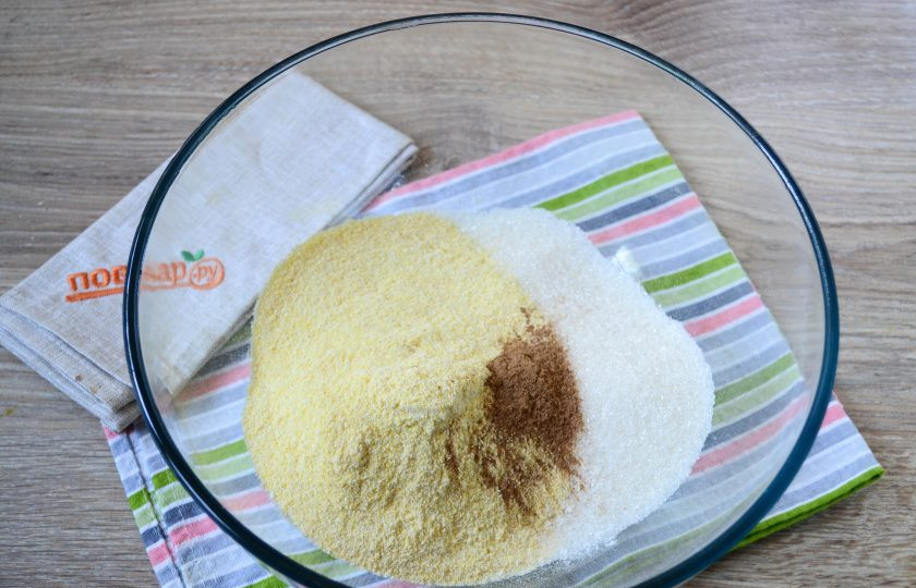 1. Этап. Тыквенно-кукурузные кексики: Смешайте все сухие ингредиенты: пшеничную и кукурузную муку, разрыхлитель, специи, сахар, соль. Перемешайте массу ложкой.