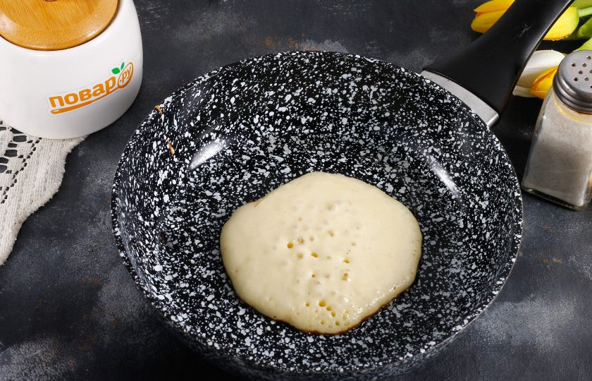 1. Этап. Панкейки на кефире с яблоками: Раскалите сковороду и смажьте ее маслом в первый раз. Влейте на дно сковороды 2 ст.л. теста и убавьте нагрев до среднего. Выпекайте, пока на поверхности панкейка не лопнут пузыри.