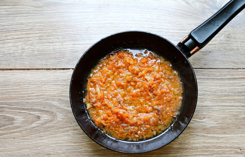 1. Этап. Суп с тушенкой из говядины: Пока варится картофель, сделайте зажарку. Репчатый лук мелко порежьте и выложите в сковороду с разогретым растительным маслом. Морковь натрите на средней или крупной терке и добавьте к луку. Обжаривайте все на среднем огне в течение 7 минут, перемешивая.