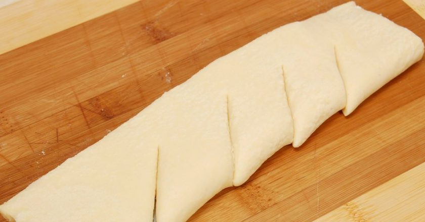 1. Этап. Яблоки и груши в слоеном тесте: Тесто разморозьте. Один пласт сверните вдвое. Сделайте на нём диагональные надрезы.