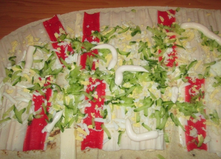 1. Этап. Рулеты из лаваша с плавленым сыром: 2. Затем разворачиваем крабовые палочки и нарезаем полосками. Выкладываем их поверх сыра, после чего посыпаем вареным натертым яйцом и смазываем майонезом.