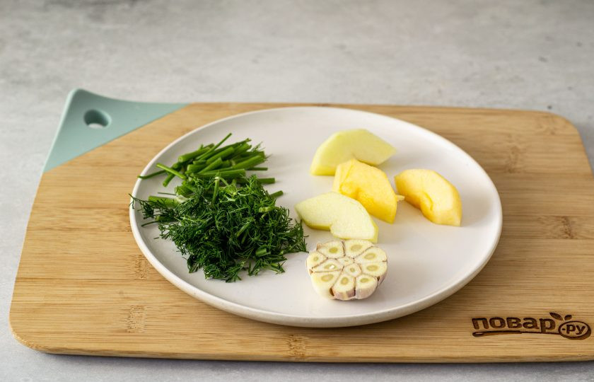 1. Этап. Быстрые малосольные огурчики: Мелко измельчите укроп со стеблями. Головку чеснока разрежьте пополам. Яблоко нарежьте на крупные дольки.