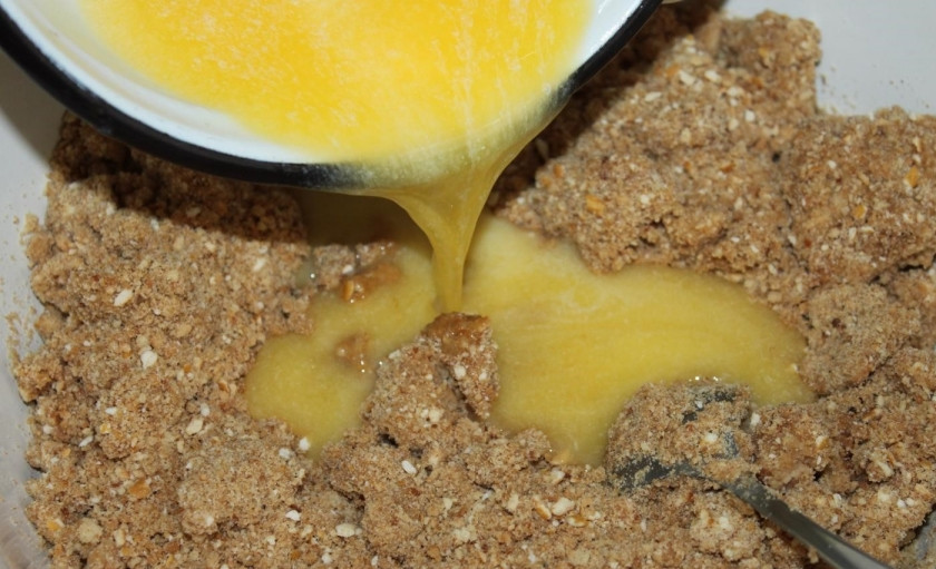 1. Этап. Пирожное Картошка со сгущенкой: 3. Растопите на медленном огне сливочное масло. После чего добавьте растопленное масло к смеси крошки с молоком.