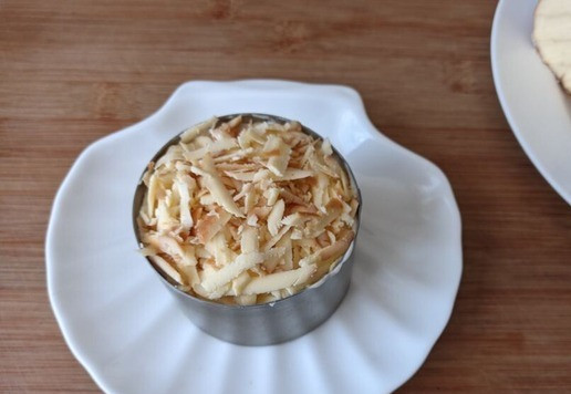 1. Этап. Салат Кудрявый Ваня: Колбасный копчёный сыр трём на тёрку. Хочу отметить, что здесь этот продукт имеет большое значение, поэтому не берите дешёвый сырный продукт. Кладём сыр верхним слоем. Этот слой не приминаем, чтобы оставались 