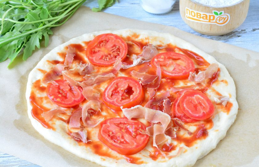 1. Этап. Пицца с прошутто и рукколой: Раскатайте тесто в тонкий пласт круглой формы. Смажьте томатным соусом, выложите кусочки помидоров и прошутто.