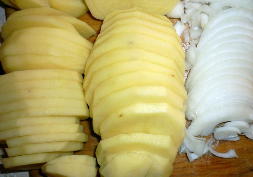 1. Этап. Запеченная курица с картошкой в мультиварке: Очищенный лук нашинкуйте полукольцами. Подготовленный картофель нарежьте кружками.