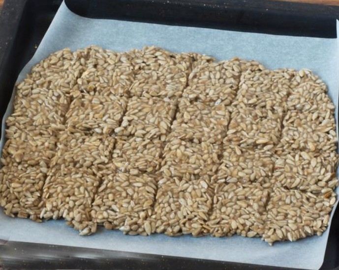 1. Stage. Kozinaki from seeds and bananas: Cover the baking sheet with parchment and oil. Transfer the cooked mass and smooth. With the dull side of the knife, make indentations in the form of squares. Dry the kozinaki in the oven at 120 ° C for 1.5-2 hours.