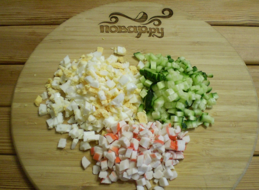 1. Этап. Салат Обезьянка с кальмарами: Покрошите мелко яйца, порежьте огурец и крабовые палочки.