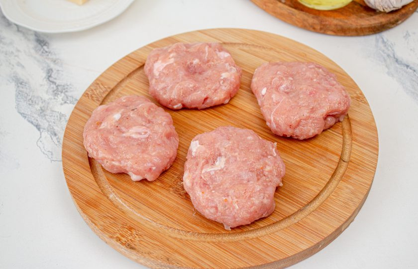 1. Этап. Куриные котлеты с сыром в мультиварке: Фарш разделите на равные 7 частей, сформируйте лепешки.