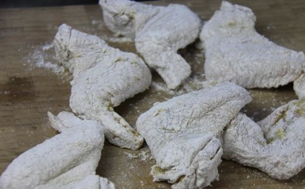 1. Этап. Крылышки во фритюре: 5. Обваляйте в яйце, а затем — в мучной панировке со всех сторон. Разогрейте в сковороде с высокими бортами растительное масло.