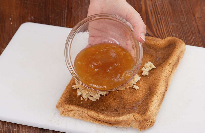 1. Этап. Бисквитное пирожное с белковым кремом: Смазываем один из коржей ягодным джемом.