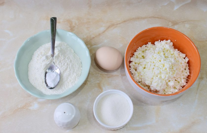 1. Этап. Творожные лепешки в духовке: Для приготовления творожных лепешек подготовьте необходимые ингредиенты. Творог можно протереть через сито или оставить с крупинками.