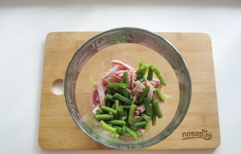 1. Этап. Салат из спаржевой фасоли с ветчиной: Спаржевую фасоль отварите в воде 5-6 минут, после воду слейте. Фасоль охладите и добавьте в салат.