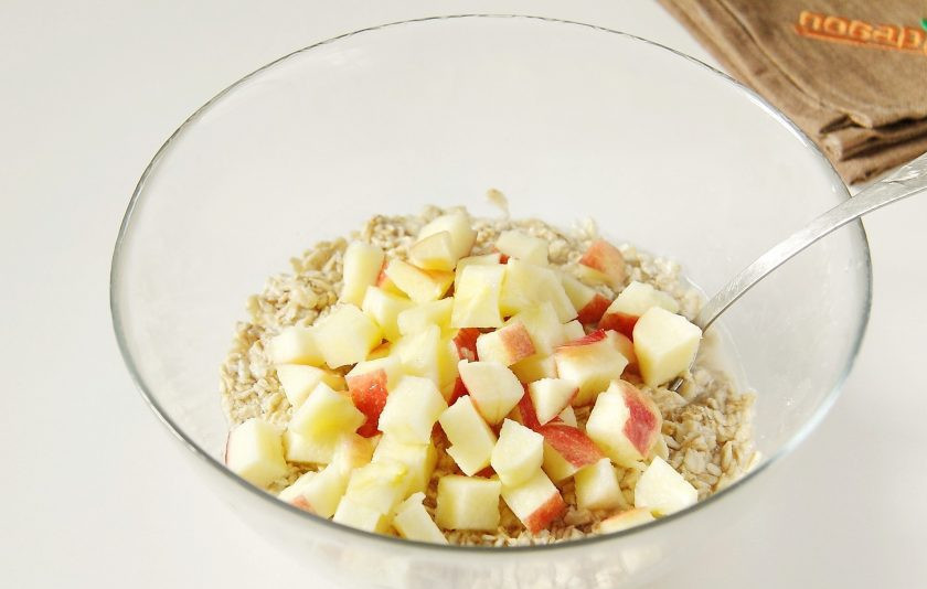 1. Этап. Овсяная запеканка с яблоком: Затем добавьте к хлопьям нарезанное кубиками яблоко.