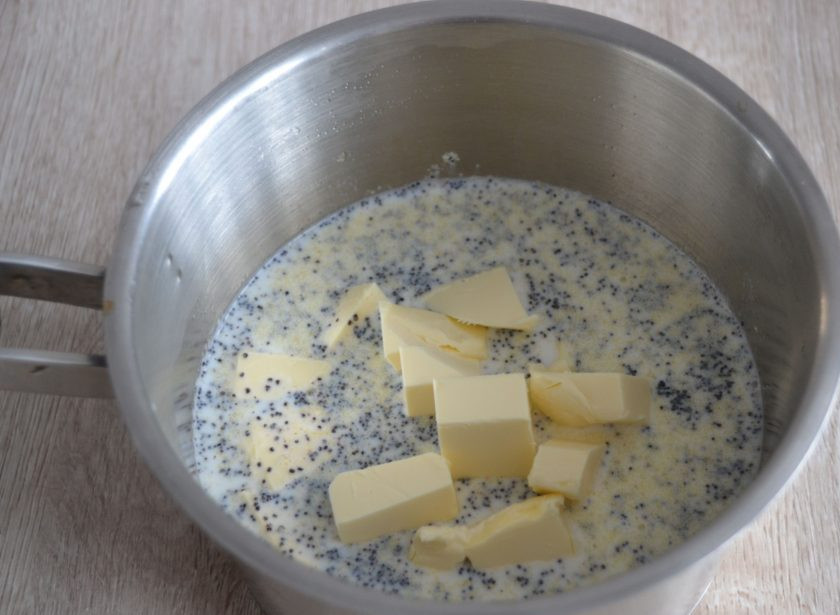 1. Этап. Маковый пирог со сметанной заливкой: Выложите в сотейник мак, манку, сахар (100 грамм), сливочное масло (100 грамм) порезанное кубиками, влейте молоко. Доведите до кипения при помешивании.