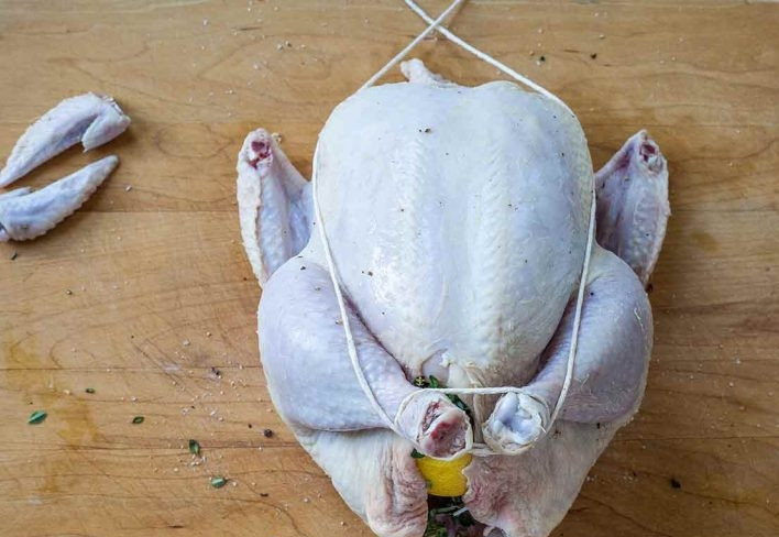 1. Этап. Запеченная курица с морковью: 3. Свяжите ноги вместе, затем протяните нитки до самого верха.