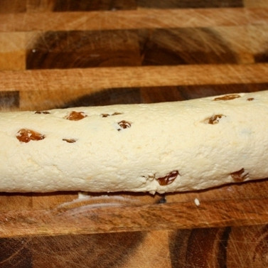 1. Этап. Сырники с изюмом (без яиц): Смешиваем творог, муку, изюм, соль и сахар. Хорошенько перемешиваем, формируем из получившегося теста колбаску, разрезаем колбаску на кусочки шириной примерно 1 см.