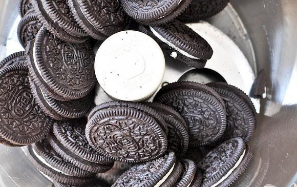 1. Этап. Шоколадные пирожные со сливочной начинкой: 2. Выложить 28 штук печенья в миску кухонного комбайна и измельчить. Поместить в большую миску, добавить растопленное масло и перемешать шпателем.