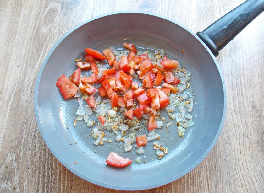 1. Этап. Кускус с баклажанами: Помидор порежьте крупным кубиком и выложите в сковороду с обжаренными овощами и специями. Тушите все в течение 5 минут.