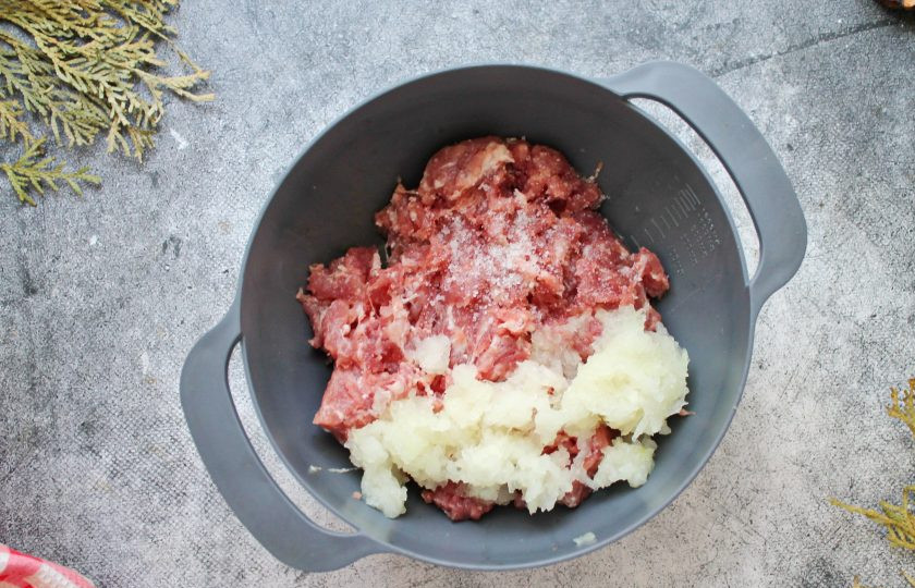 1. Этап. Пельмени из кабана: Репчатый лук почистите, порежьте и пропустите так же через мясорубку, добавьте к фаршу. Все посолите, поперчите, добавьте специи и все хорошо перемешайте.