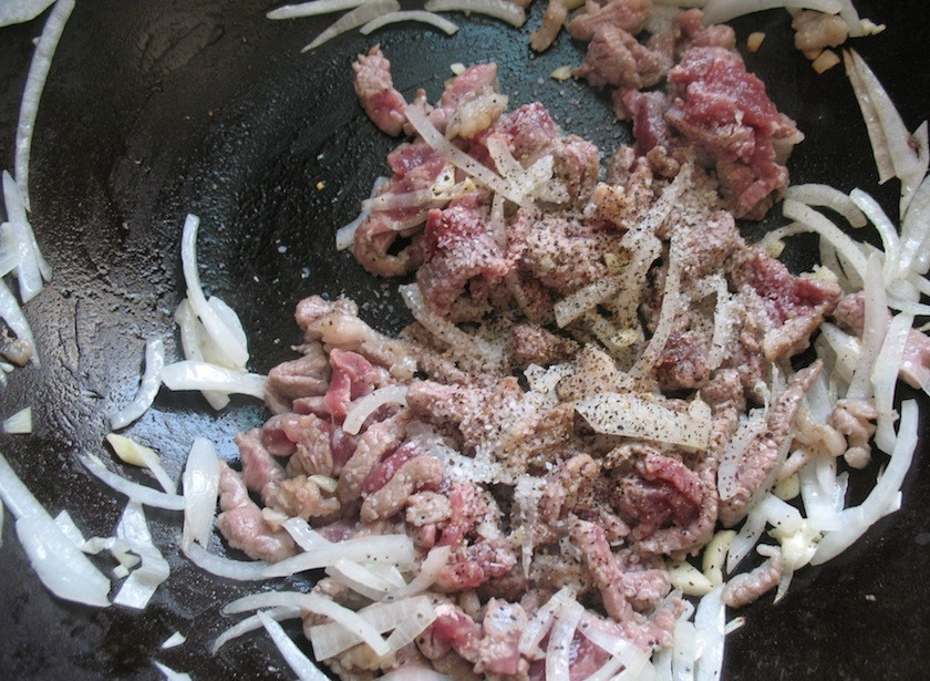 1. Этап. Цуйван: 5. Разогрейте вок с небольшим количеством растительного масла, добавьте лук, а спустя пару минут мясо, посолите и поперчите, влейте соевый соус и немного уксуса.