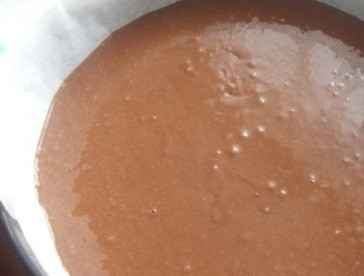 1. Этап. Домашний торт Пьяная вишня: Вливаем кипяток и быстро перемешиваем тесто. Форму для выпечки застилаем пергаментом, выливаем в форму тесто.