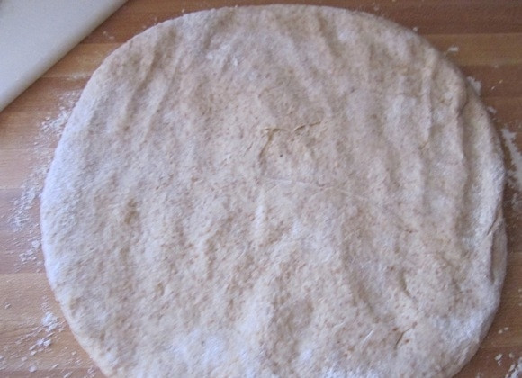 1. Этап. Тесто для пиццы из цельнозерновой муки: 9. Выложите тесто из миски на стол и надавите по центру, затем руками сформируйте лепешку.