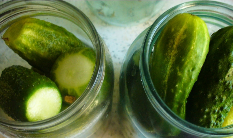 1. Этап. Закатка огурчиков: 2. Тем временем стерилизуем банки. На дно каждой поместим по зубчику чеснока, перчик, лавровый лист и по одной маленьком луковке. Дальше закладываем подготовленные огурцы.