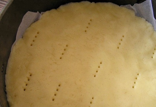 1. Этап. Торт Белый танец: Форму для выпечки (у меня диаметром 18 см) застелите пекарской бумагой, распределите тесто, проколите вилкой в нескольких местах.