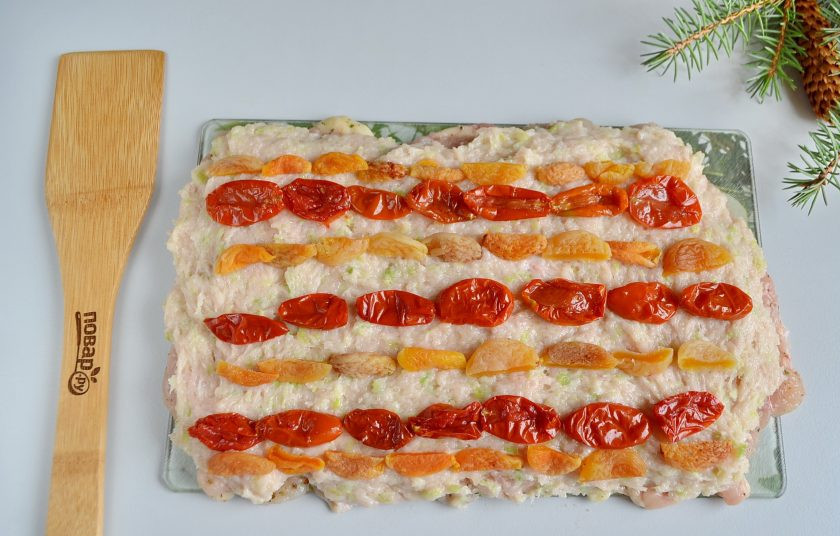 1. Этап. Куриный рулет в гранатовом желе: Распределите вяленые томаты и курагу.