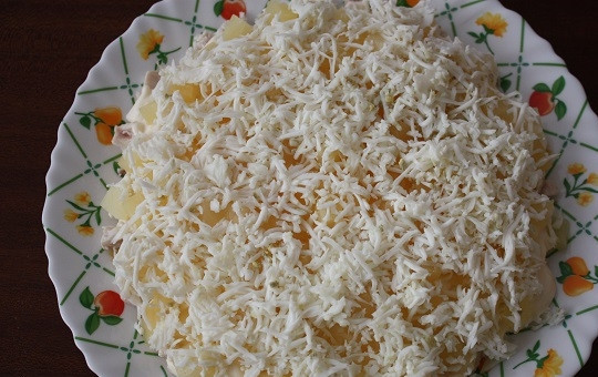 1. Этап. Салат с куриным филе и ананасами: 5. Яйца остудите и очистите, отделите белки от желтков. Белки натрите на терке и выложите поверх ананасов.