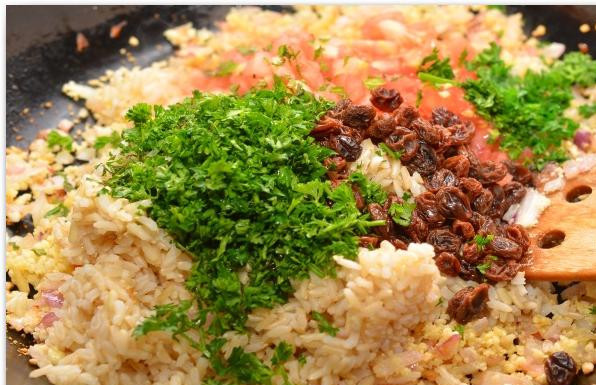 1. Этап. Фаршированные перцы и помидоры: Затем добавляем в сковороду мякоть помидоров, изюм, рис и зелень. Перемешиваем, прогреваем пару минут и снимаем с огня.