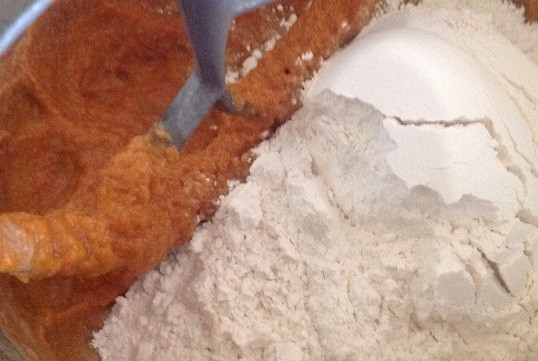 1. Этап. Тыквенно-шоколадные булочки: 5. Понемногу всыпайте просеянную с солью муку, замешивая тесто. Добавьте для аромата специи.