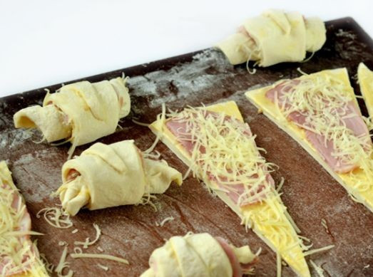 1. Этап. Круассаны с сыром и ветчиной: Заворачиваем круассаны, начиная с широкой части треугольника. Края получившегося изделия слегка отгибаем, чтобы получилась форма полумесяца.