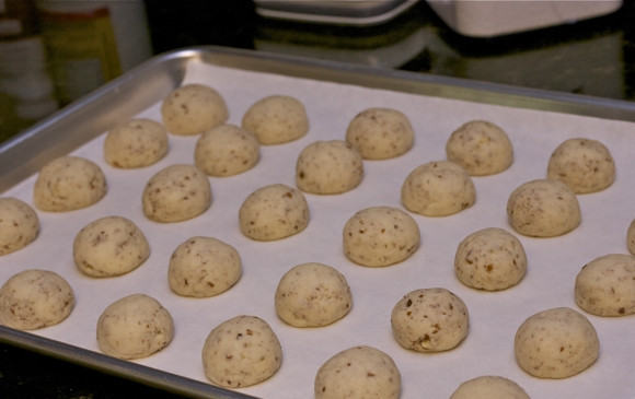 1. Этап. Ореховые пирожные на десерт: Сформируйте из теста шарики, выложите на противень, застеленный пергаментной бумагой, и отправьте в духовку, разогретую до 150 градусов, на 25 минут.