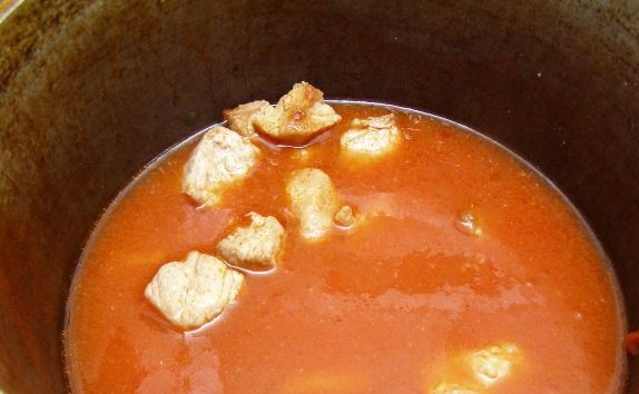 1. Этап. Мясо, тушенное в сметане: Влейте в казанок несколько стаканов горячей воды. Хорошенько все перемешайте, чтобы томатная паста полностью растворилась в воде. Накройте казанок крышкой и на маленьком огне тушите свинину сорок минут.