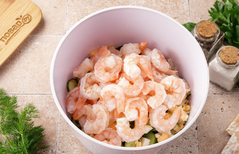 1. Этап. Салат с кальмаром, креветками и огурцом: Добавьте варёные креветки. Если у вас сырые креветки, тщательно их промойте и отварите в подсоленной воде пару минут, затем дайте остыть и снимите панцирь с хвостиками.