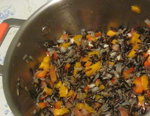 1. Этап. Рис, запеченный в тыкве: На сковороде сначала обжарьте на оливковом масле измельченный чеснок с луком. Затем добавьте к ним специи, помидор, болгарский перец, рис и тыкву (мякоть, которую мы вычистили). Пару минут все обжаривайте. Также добавьте сыр тертый.