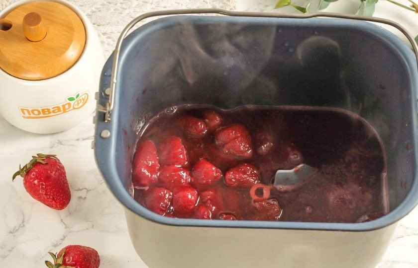 1. Этап. Джем из клубники в хлебопечке: Спустя половину указанного времени приоткройте крышку и проверьте готовность варенья. Ягодки должны стать полуразваренными в сладком клубничном сиропе.