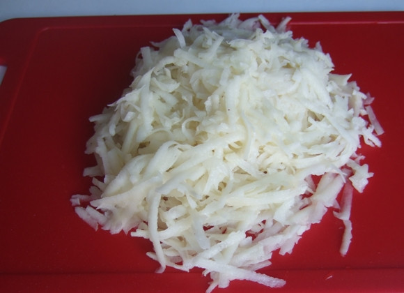 1. Этап. Мясо в сливках в духовке: Сырую картошку чистим, моем и натираем на терке.