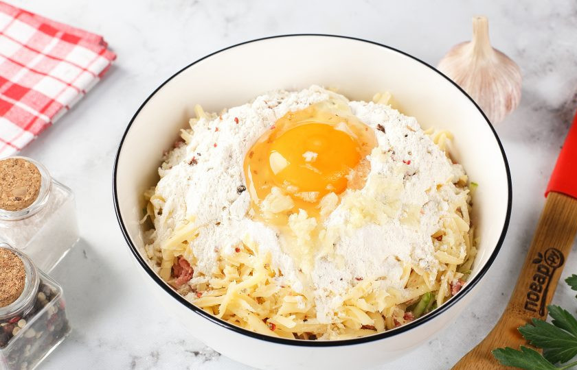 1. Этап. Запеканка из кабачков с копчёной колбасой и сыром: Затем добавьте муку, яйцо, соль и молотый перец по вкусу.