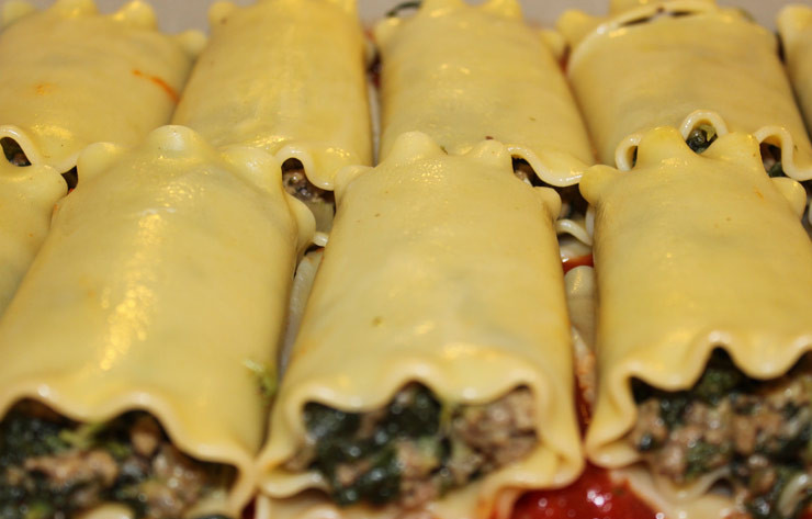 1. Этап. Каннеллони в томатном соусе: 4. На дно жаропрочной формы выложить пару ложек томатного соуса. Нафаршировать каннеллони остывшей начинкой и выложить в форму.